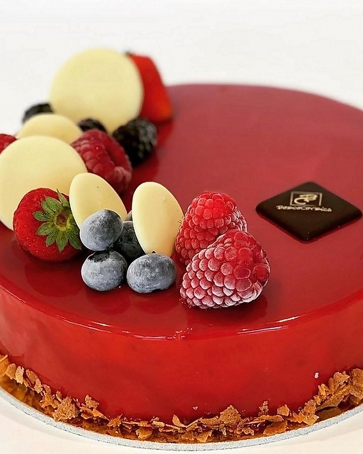 Torta personalizzata con glassa rossa e frutti di bosco